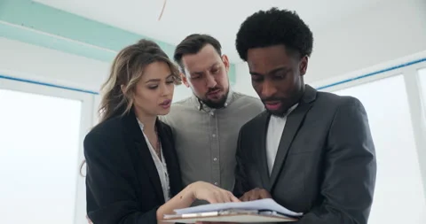 As the couple eagerly listens, the African real estate agent points out the Stock Footage 277682588