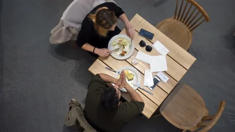 Couple eat and talk at a table in 4K. View from above Stock Footage 125660981