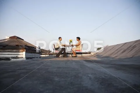 A couple eating a meal on a rooftop terrace Stock Photos