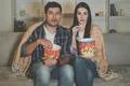 The couple eating popcorn and watch a horror movie on the sofa Photo