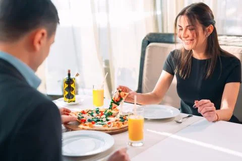 A couple eats pizza in a restaurant. Stock Photos