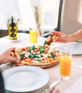 A couple eats pizza in a restaurant. Stock Photos