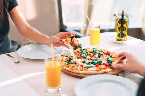 A couple eats pizza in a restaurant. Stock Photos
