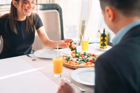 A couple eats pizza in a restaurant. 写真素材