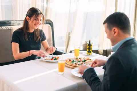 A couple eats pizza in a restaurant. Stock Photos