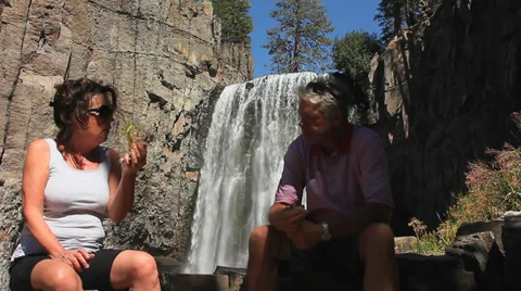 COUPLE EATS AT WATERFALL Stock Footage 28837182