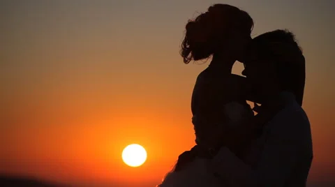 Couple embrace on a background of a sunset Stock Footage 56249644