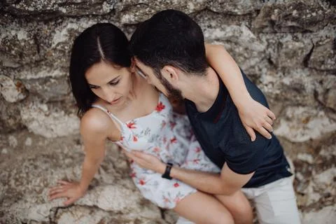 Couple embraced while sitting on stone street Stock Photos