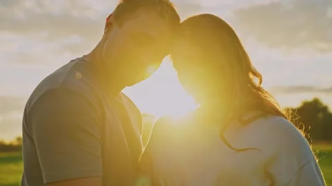 Couple embraces in sunset glow during an outdoor moment of connection Видео 286316147