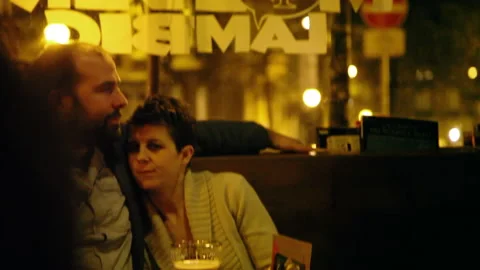Couple Embracing at Beer Bar Table Inside a Pub at Night 스톡 동영상 346817822