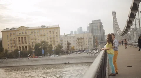 Couple embracing on the bridge and look at the river Stock Footage 55336558