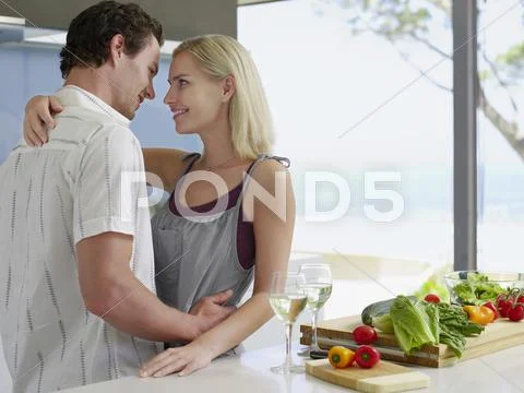 Couple Embracing With Fresh Vegetables On Kitchen Counter Stock Photos