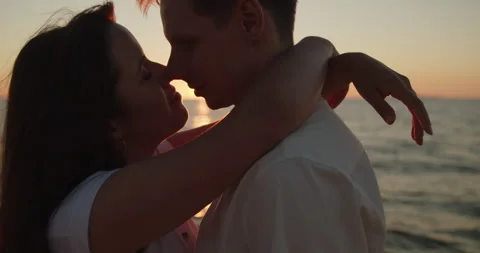 Couple embracing in sunset light standing together on the beach Stock Footage 220729009
