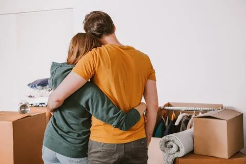 Couple Embracing While Facing Moving Boxes Stock Photos
