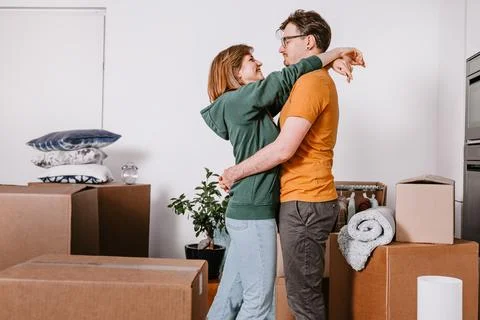 Couple Embracing While Moving Into New Home, Unpacking, Moving in Stock Photos