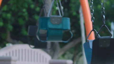 A couple of empty moving swings at playground Stock Footage 121187226