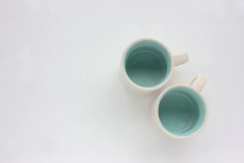 Couple of empty white espresso coffee cups blue inside on white table. Foto stock