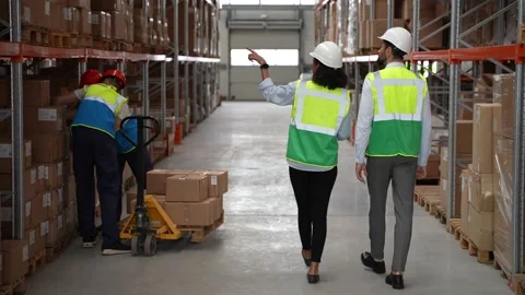 Couple of engineers during work in factory storage Stock Footage 161953934