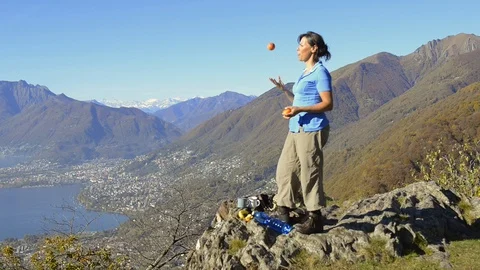 Couple Enjoy the Panoramic View over Mountains and Throwing an Apple 動画素材 111697792