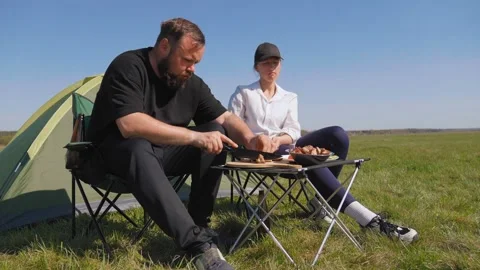 Couple enjoying barbecue picnic while camping 動画素材 344606119