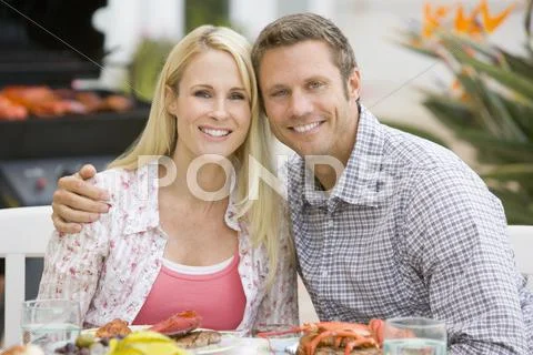 Couple enjoying a barbequed meal in the garden Stock-Fotos