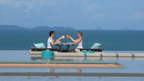 Couple enjoying breakfast in infinity pool 库存影片 91562199