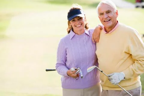 Couple enjoying a game of golf Stock Photos