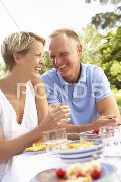 Couple Enjoying Meal In Garden Stock Photos