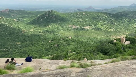Couple enjoying on mountain top, mountain view with couple sitting on rock Stock Footage 159241663