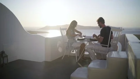 Couple enjoying romantic dinner outside on santorini island Stock Footage 80234715