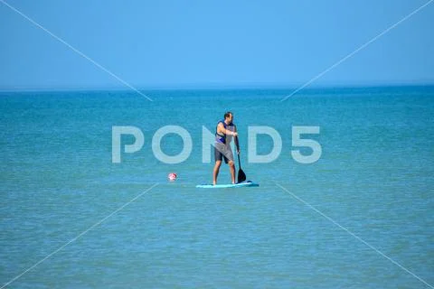 Couple enjoying stand up paddle board on blue sea background 2 Stock Photos