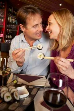 Couple Enjoying Sushi In Restaurant Stock Photos