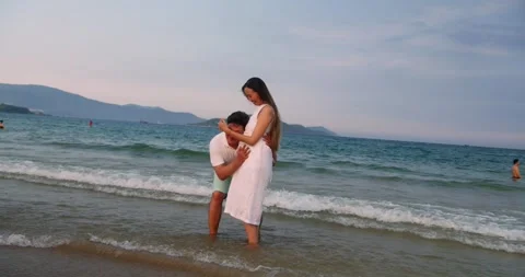 Couple enjoys their vacation while awaiting their baby. Young Partner listens to Stock Footage 315301198