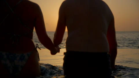 Couple enter pool at sunset in Luxury Vacation Villa Stock Footage 247288892