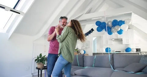 Couple entering balloon-lined loft celebrating party and holding hands while 스톡 동영상 317096771