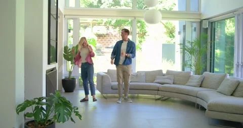 Couple entering center space, starting playful dance across open floor near Stock Footage 342019010
