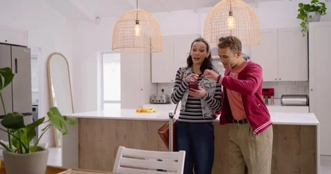 Couple entering kitchen, checking after suitcase arrival, woman showing Stock Footage 342608100