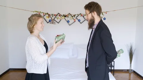Couple exchange the same Chrismas present in a authentic room. Stock Footage 102656066