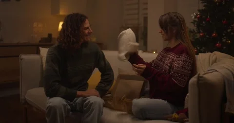 Couple exchanges gifts while enjoying cozy holiday atmosphere in beautifully Stock Footage 318040090