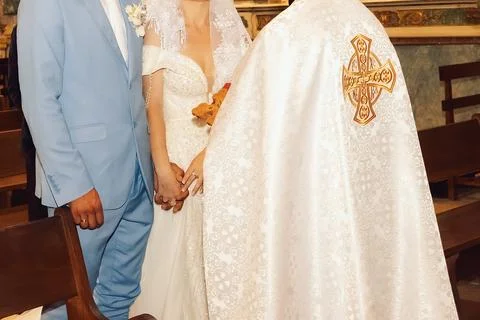 Couple exchanges vows during ceremony in church setting, holding hands and we 库存照片