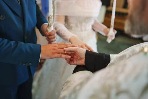 Couple exchanges wedding rings during intimate ceremony at historic venue Stock Photos