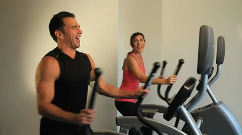 Couple exercising on elliptical machines Stock Footage 36763137