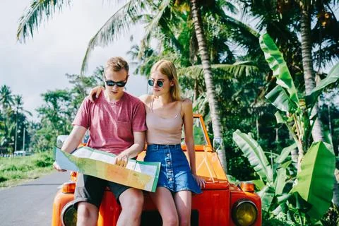 Couple exploring map while traveling by car Stock Photos