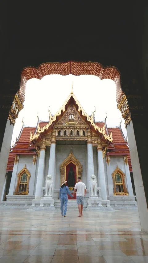 Couple exploring the stunning architecture of a temple in Thailand during their Stock Footage 331059602