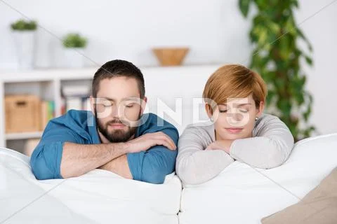 Couple with eyes closed on sofa Stock Photos