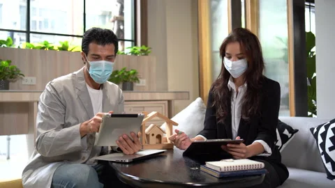 Couple in face mask talking and working with tablet together in office.  busi Stock Footage 168668144