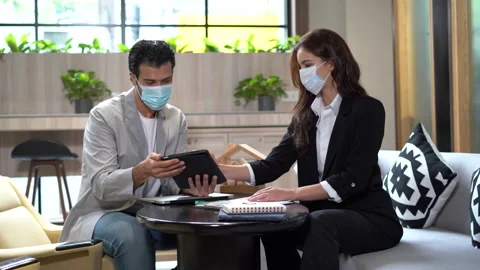 Couple in face mask talking and working with tablet together in office.  busi Stock Footage 168669714