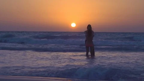Couple is falling in love on beach at sunset. Young woman with husband is Видео 79303981