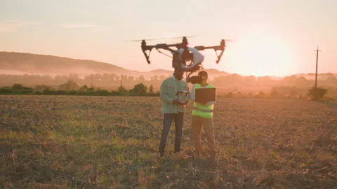 Couple of farming engineers collaborating in rural meadow, controling drone Stock Footage 162977105