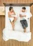 The couple fight pillows on the bed. View from above Photo